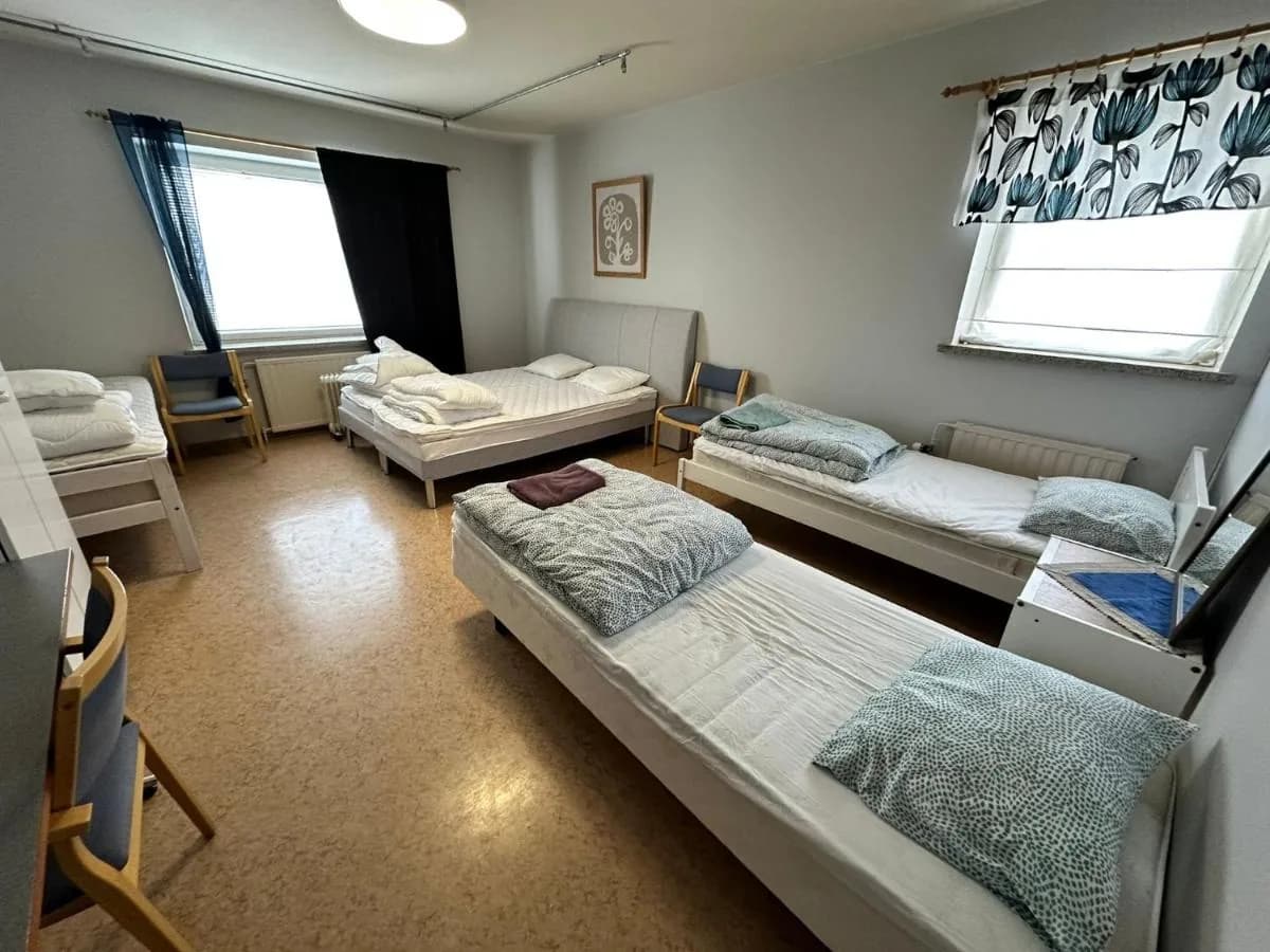 Tilava perhehuone kolmella yhden hengen vuoteella ja parivuoteella
